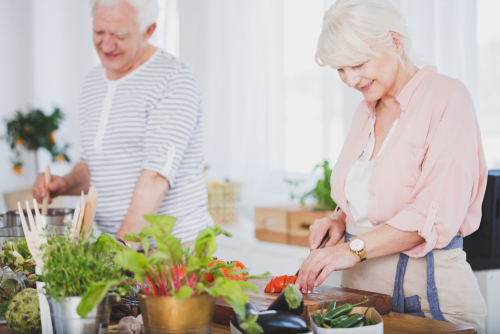 husband and wife preparing food in kitchen