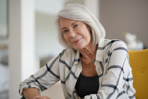 woman smiling while sitting on chair at home